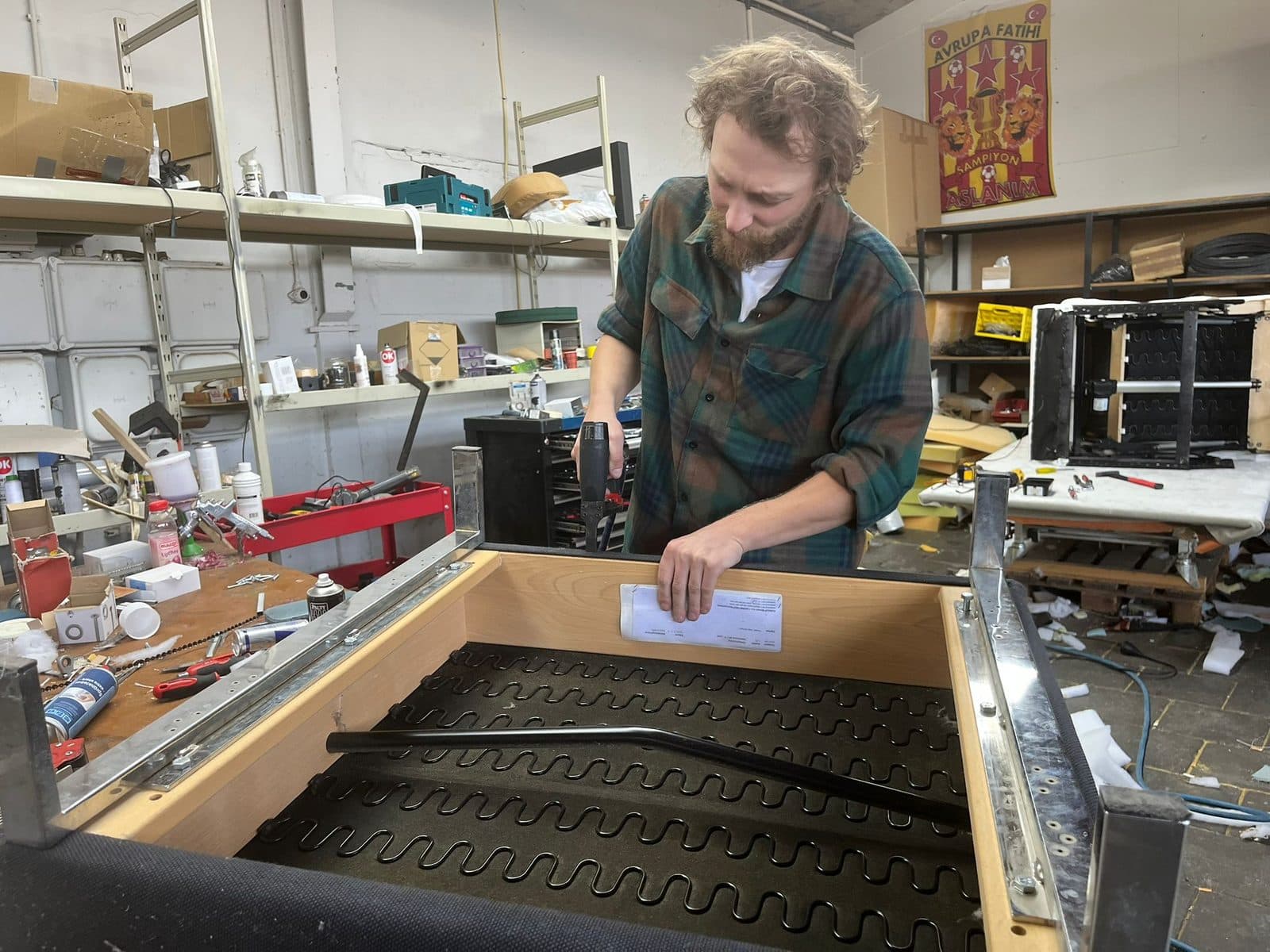 In de werkplaats wordt een uitgenomen zittingframe met veren gecontroleerd